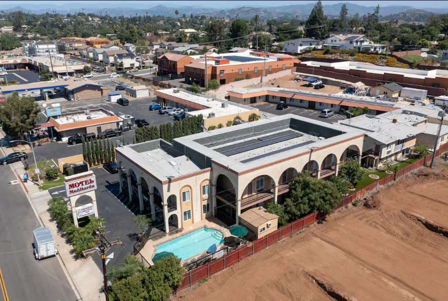 Aerial view of the motel rooftop, pool, and surrounding neighborhood